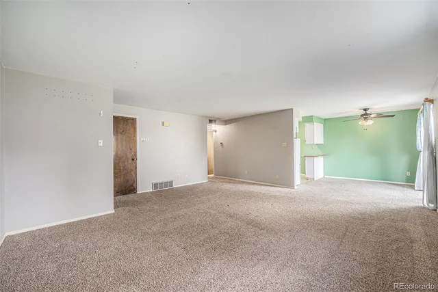 a view of a big room with windows and chandelier fan