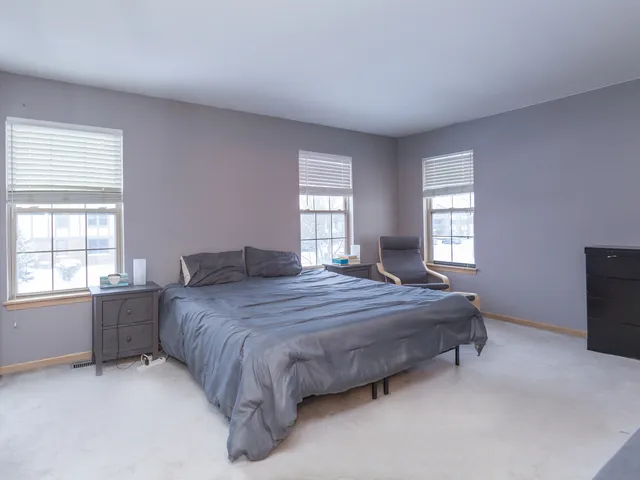 a bedroom with a bed dresser and a window