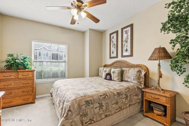 a bedroom with a bed dresser and a flat tv screen