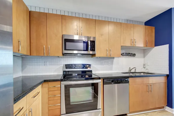 a kitchen with stainless steel appliances wooden cabinets and a stove top oven