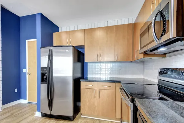 a kitchen with stainless steel appliances granite countertop a refrigerator and a stove