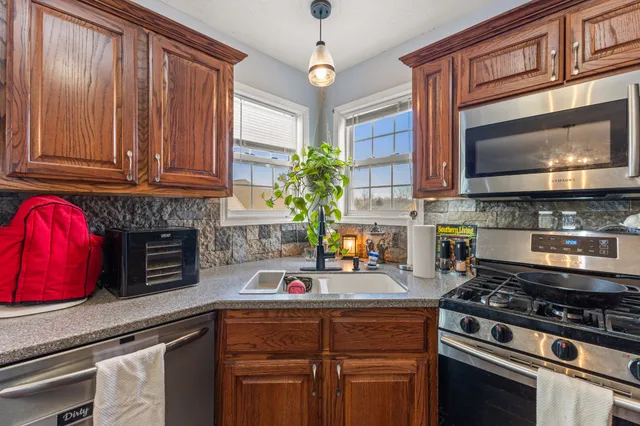 a kitchen with stainless steel appliances granite countertop a stove a microwave a sink and cabinets