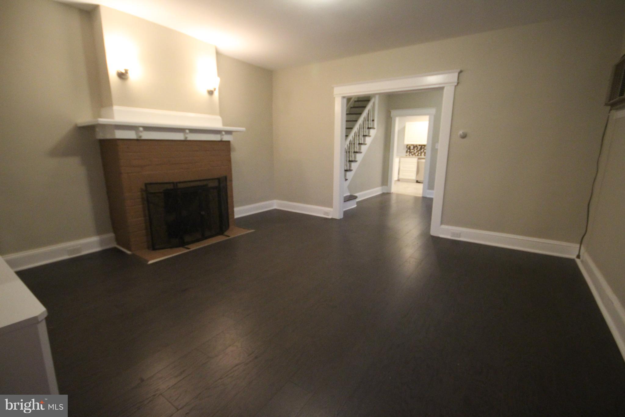 162 Edinburg Road Hamilton, NJ 08619 - Photo 4 of 17 an empty room with wooden floor a fireplace and windows
