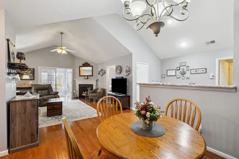 a view of a dining room with furniture a chandelier and wooden floor