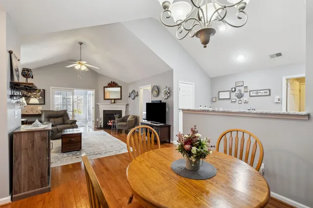a view of a dining room with furniture a chandelier and wooden floor
