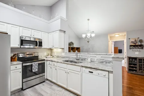 a spacious bedroom with a bed a fireplace and a flat tv