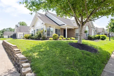 a front view of a house with a yard patio and green space