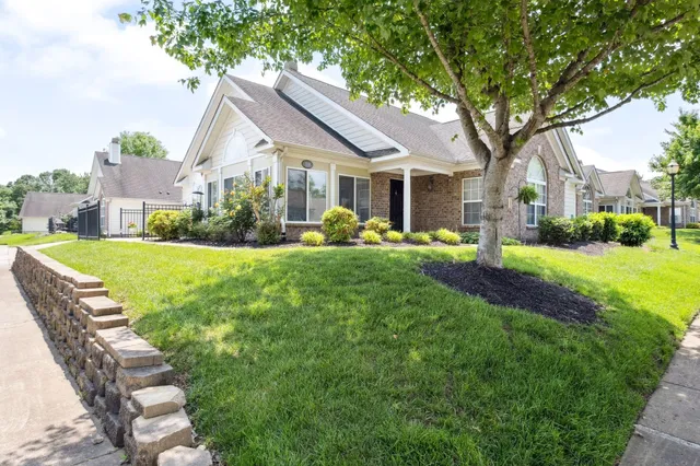 a front view of a house with a yard patio and green space