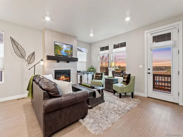 a living room with furniture a flat screen tv and a fireplace