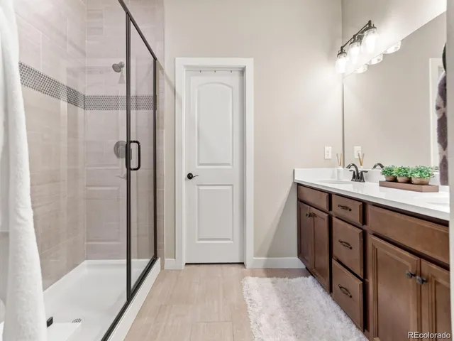 a bathroom with a shower sink and mirror