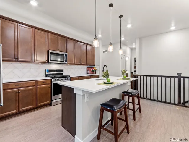 a kitchen with kitchen island granite countertop wooden cabinets and white appliances