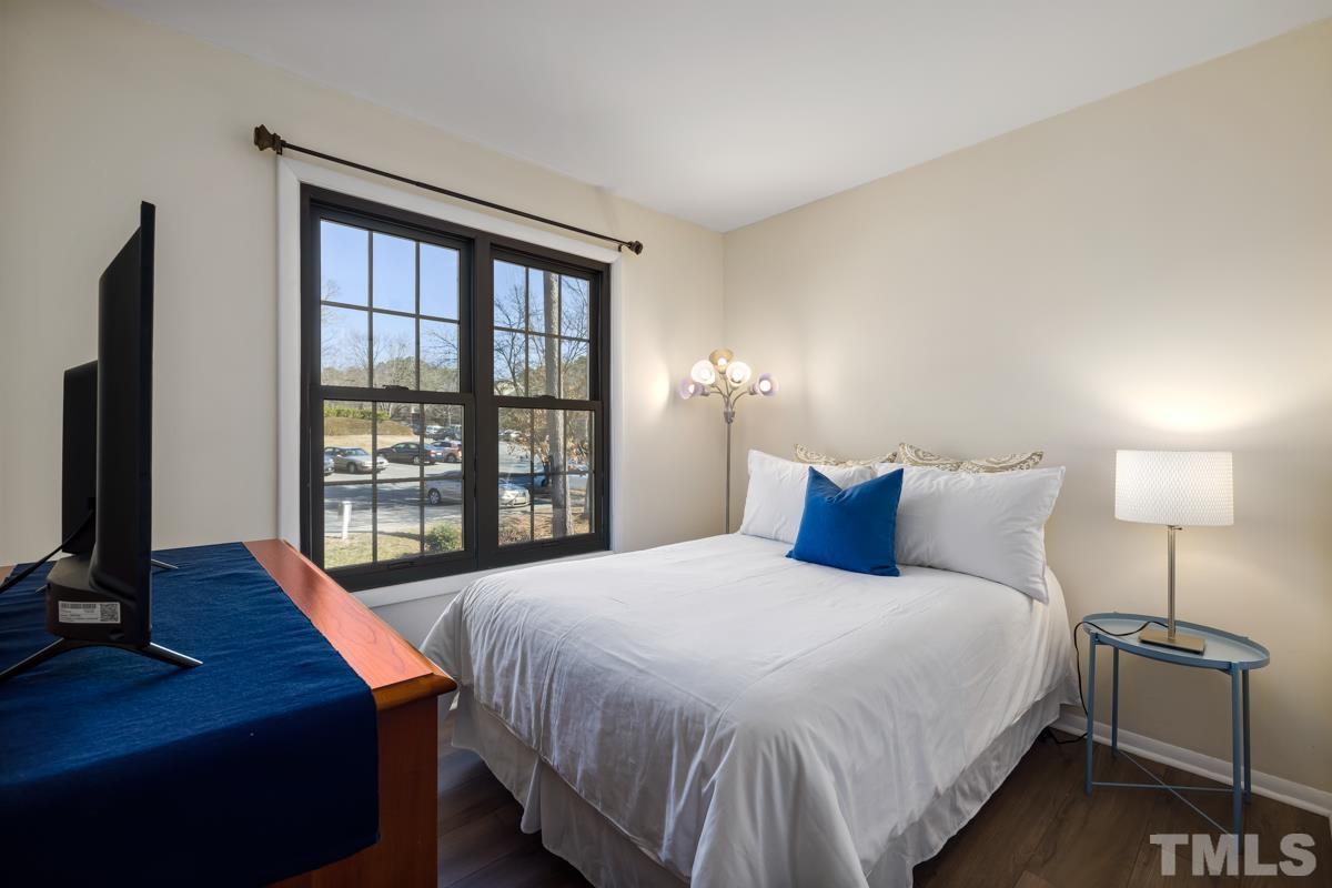 3702 Chimney Ridge Place, Unit 201 Durham, NC 27713 - Photo 18 of 27 a bedroom with a bed and a flat tv screen on a dresser