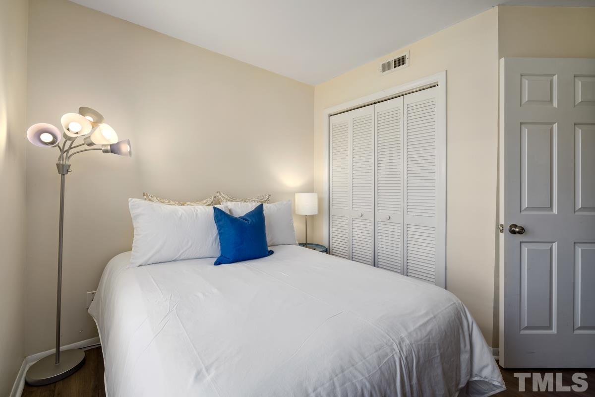 3702 Chimney Ridge Place, Unit 201 Durham, NC 27713 - Photo 19 of 27 a bedroom with a bed and a mirror