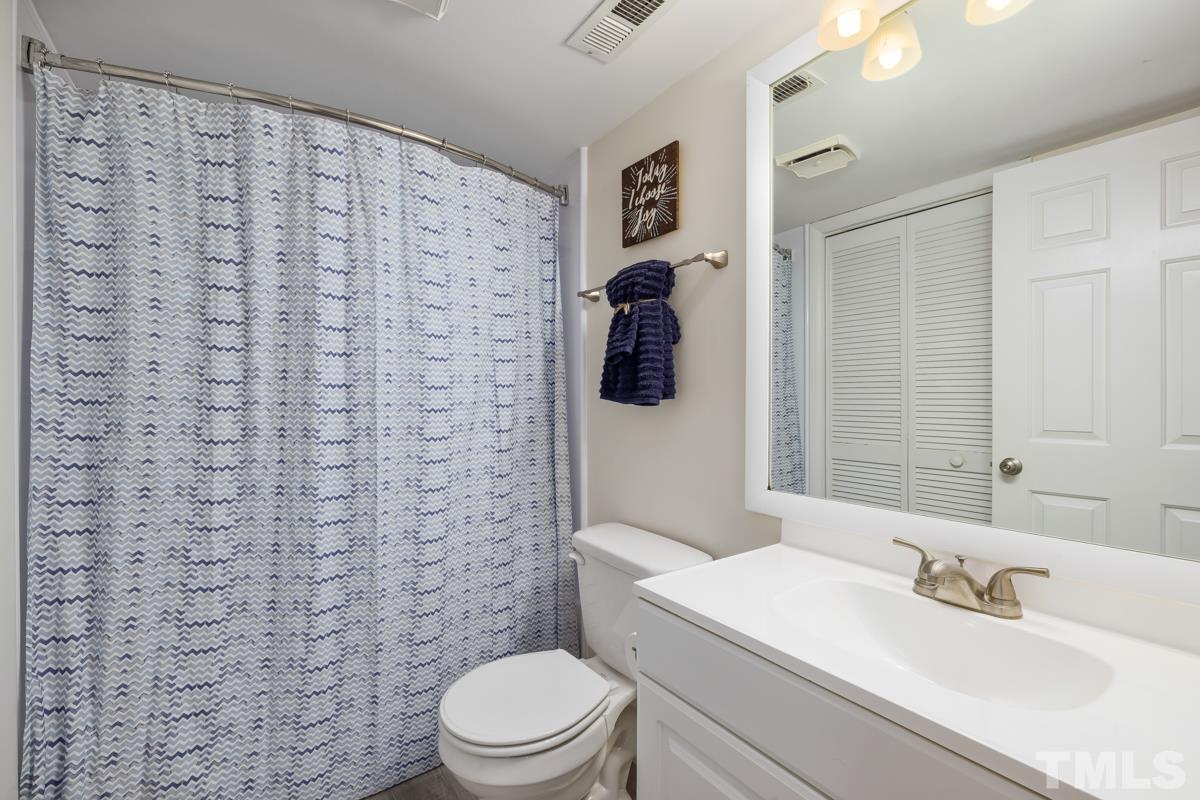 3702 Chimney Ridge Place, Unit 201 Durham, NC 27713 - Photo 21 of 27 a bathroom with a sink a toilet and shower curtain