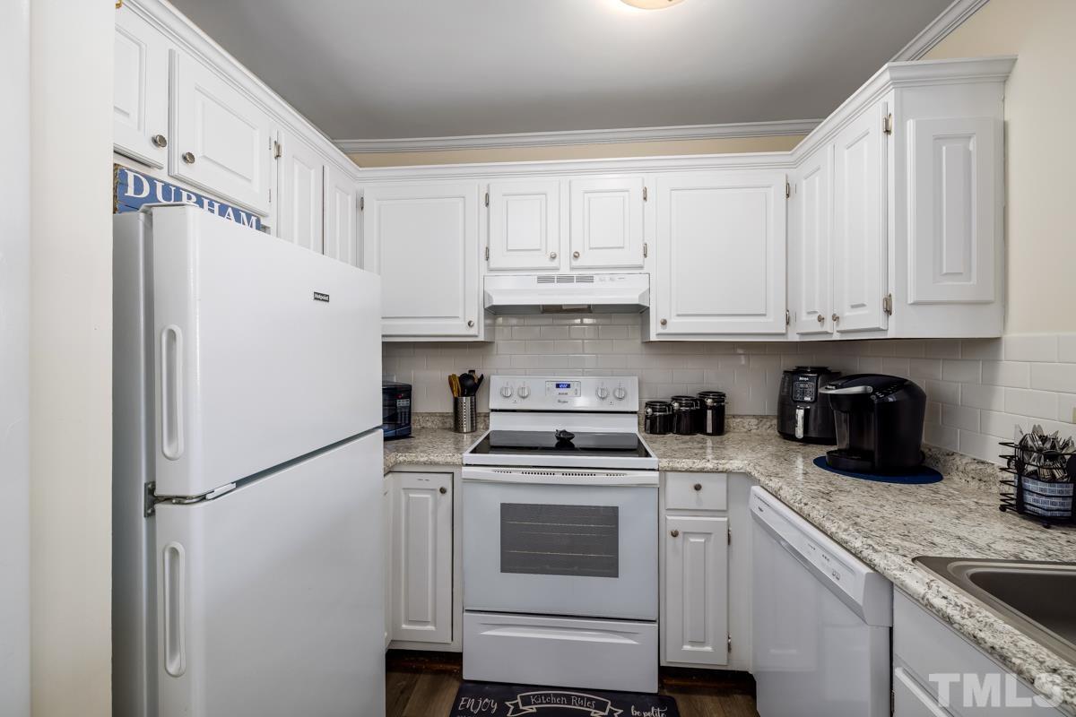 3702 Chimney Ridge Place, Unit 201 Durham, NC 27713 - Photo 6 of 27 a kitchen with white cabinets and white appliances