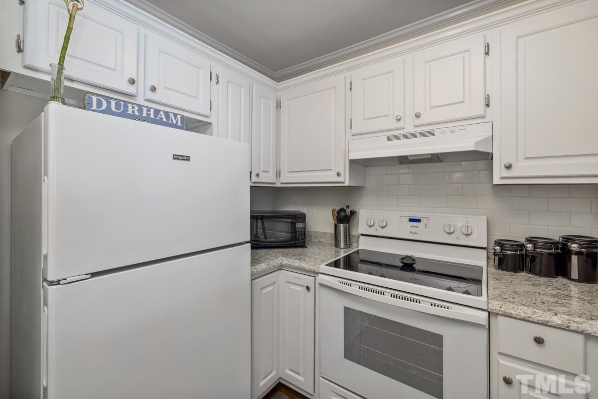 3702 Chimney Ridge Place, Unit 201 Durham, NC 27713 - Photo 8 of 27 a kitchen with stainless steel appliances white cabinets and a refrigerator