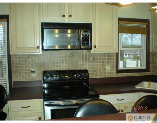 11 Stevens Road Edison, NJ 08817 - Photo 5 of 14 a kitchen with a stove and cabinets
