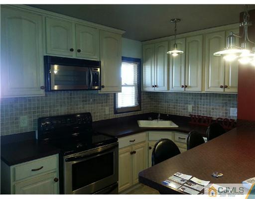 11 Stevens Road Edison, NJ 08817 - Photo 6 of 14 a kitchen with granite countertop a stove a sink and a microwave
