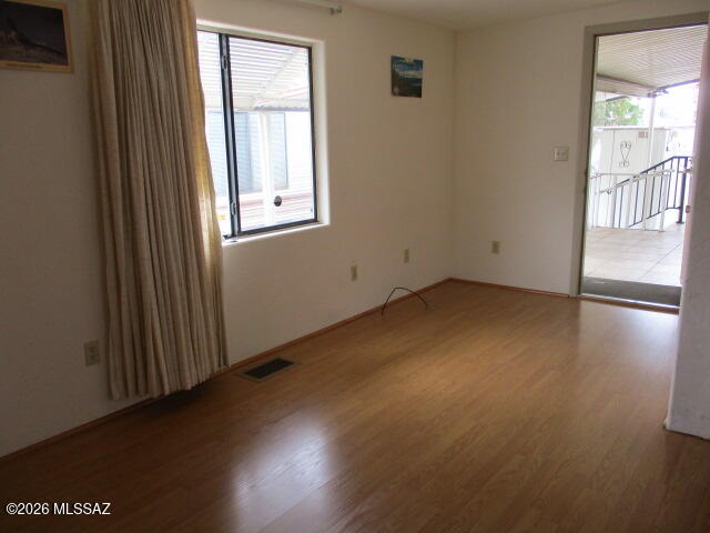 3100 South Kinney Road, Unit 193 Tucson, AZ 85713 - Photo 6 of 35 an empty room with wooden floor and windows
