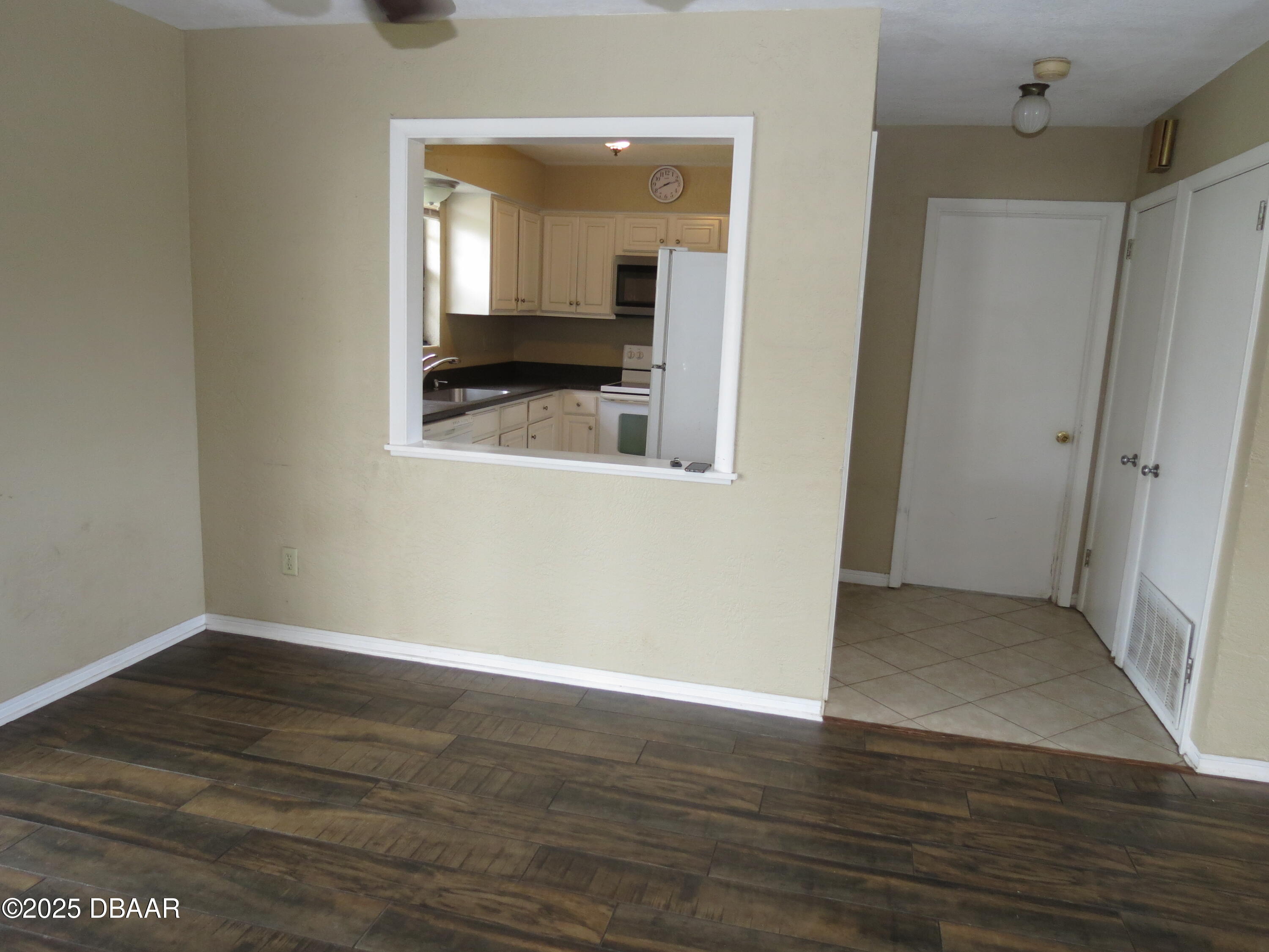 221 Williams Avenue Daytona Beach, FL 32118 - Photo 4 of 15 a view of an empty room with wooden floor and a mirror