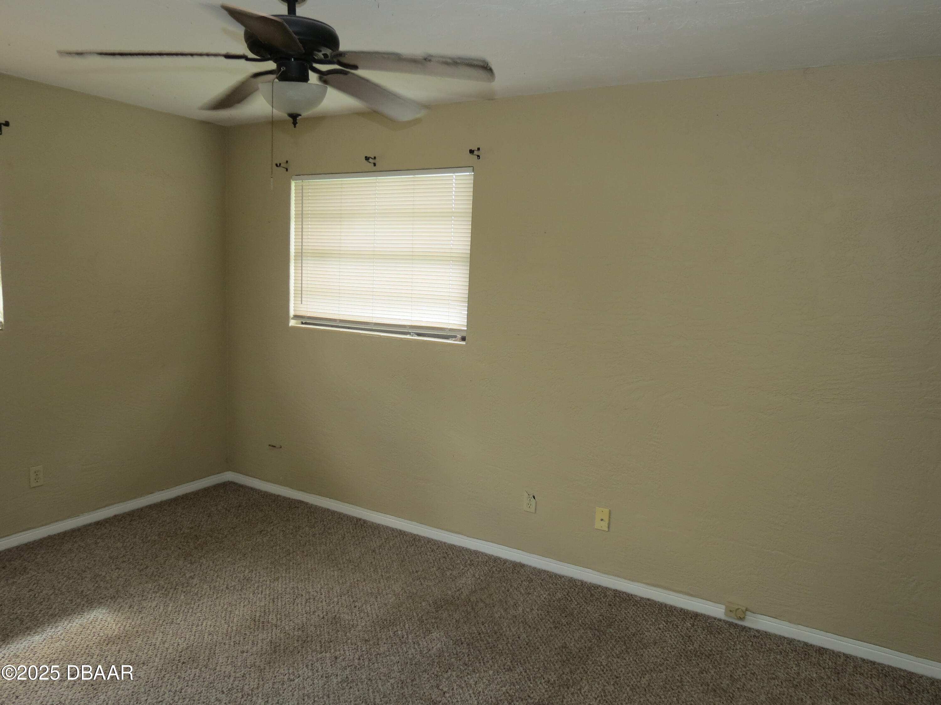 221 Williams Avenue Daytona Beach, FL 32118 - Photo 8 of 15 an empty room with a window and a fan