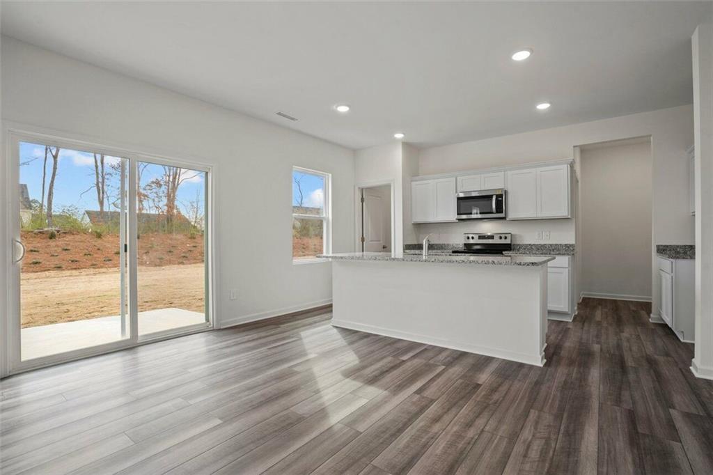 212 Champions Boulevard Dallas, GA 30157 - Photo 3 of 19 a kitchen with wooden floors and appliances