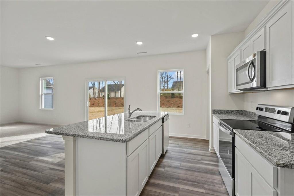 212 Champions Boulevard Dallas, GA 30157 - Photo 5 of 19 a kitchen with granite countertop a sink and a stove top oven
