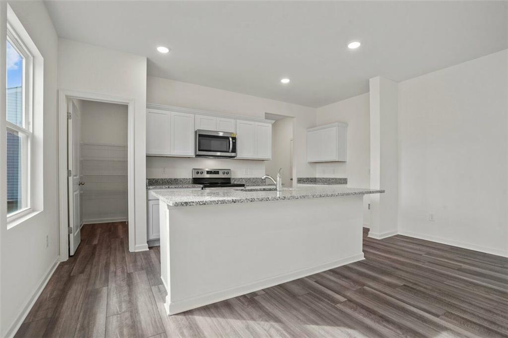 212 Champions Boulevard Dallas, GA 30157 - Photo 7 of 19 a kitchen with stainless steel appliances a refrigerator and a stove top oven