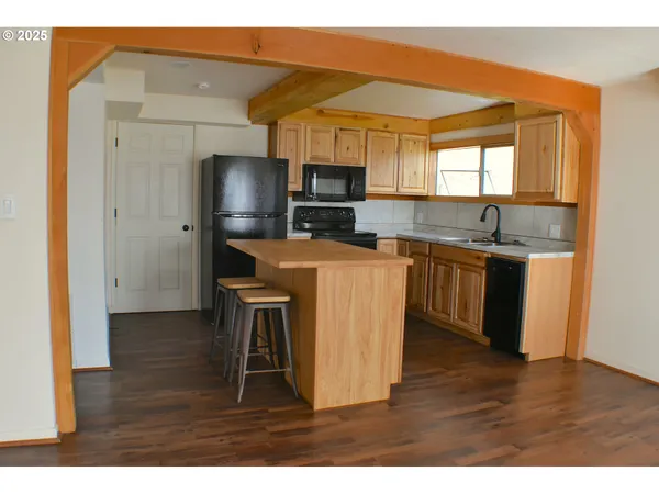 a kitchen with kitchen island a sink stove and refrigerator
