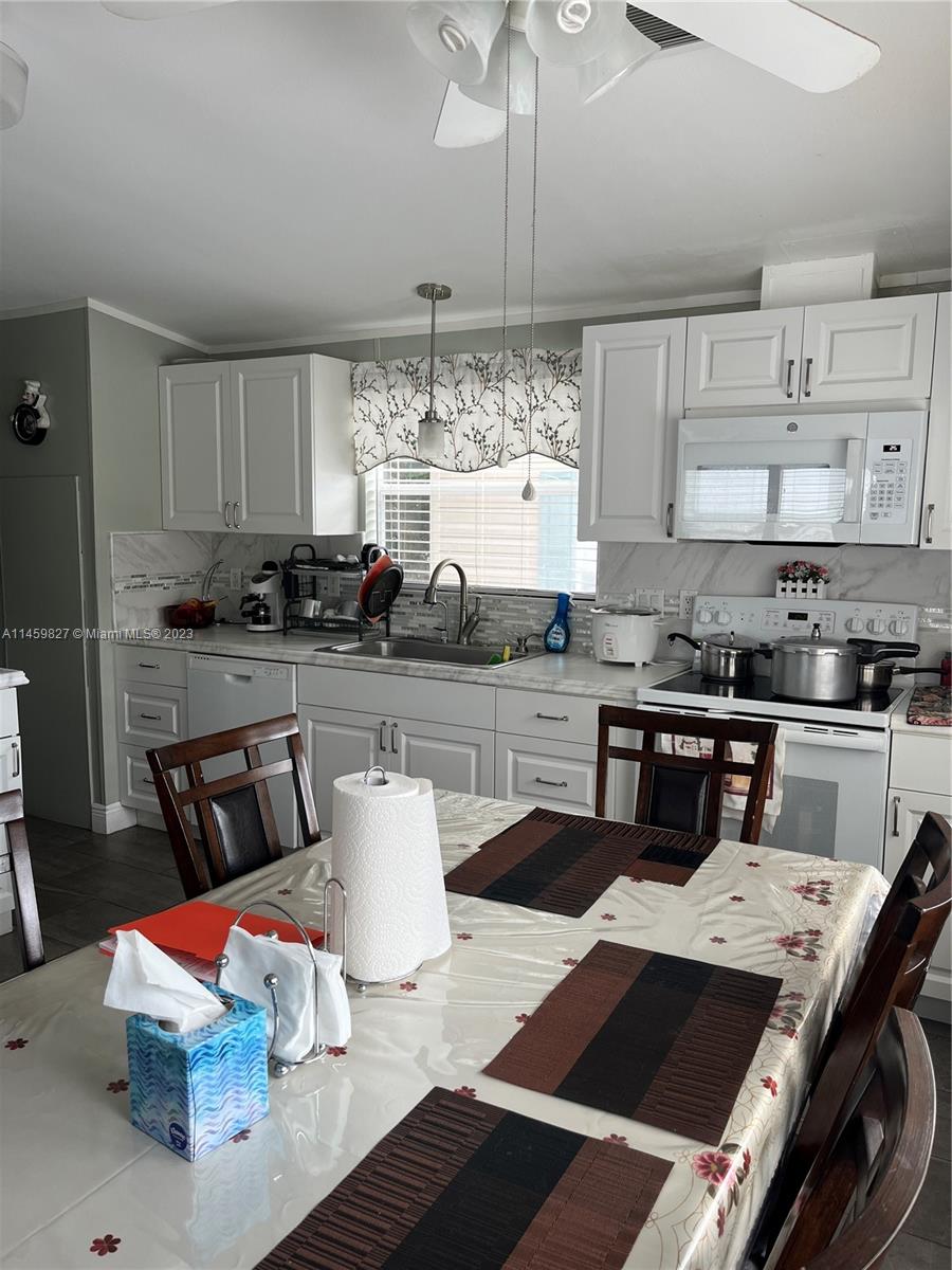 28501 Southwest 152nd Avenue Homestead, FL 33033 - Photo 2 of 32 a kitchen with stainless steel appliances kitchen island granite countertop a sink and white cabinets