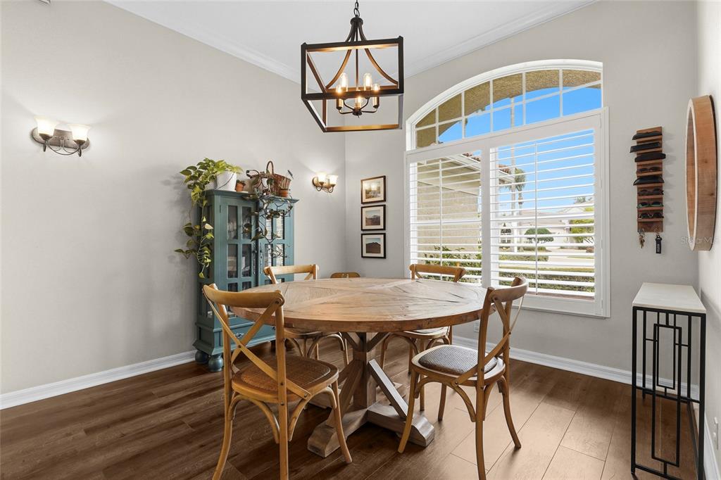 6582 Waters Edge Way Lakewood Ranch, FL 34202 - Photo 24 of 98 a view of a dining room with furniture a chandelier and wooden floor