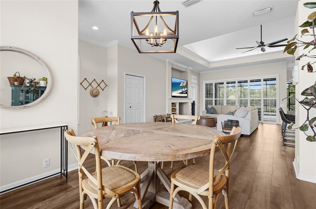 6582 Waters Edge Way Lakewood Ranch, FL 34202 - Photo 25 of 98 a view of a dining room with furniture a chandelier and wooden floor