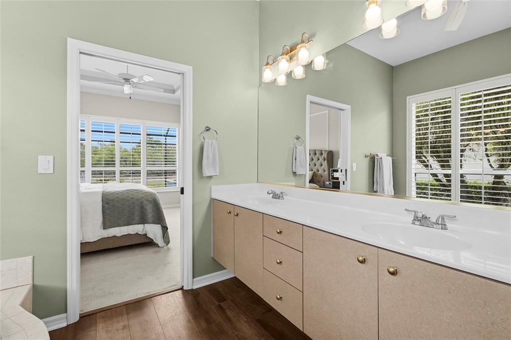 6582 Waters Edge Way Lakewood Ranch, FL 34202 - Photo 30 of 98 a en suite bathroom with a double vanity sink a large mirror and a window