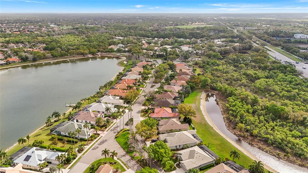 6582 Waters Edge Way Lakewood Ranch, FL 34202 - Photo 63 of 98 an aerial view of lake and residential houses with outdoor space
