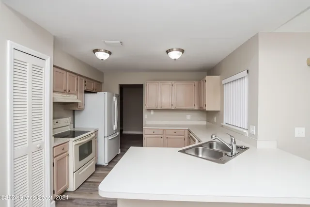 a kitchen with stainless steel appliances a refrigerator sink and stove