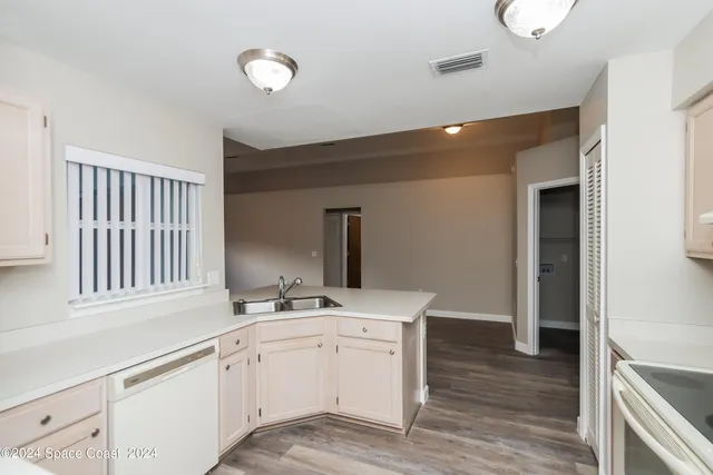 a kitchen with a sink cabinets and wooden floor