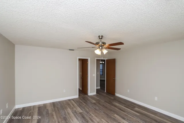 an empty room with closet and a ceiling fan