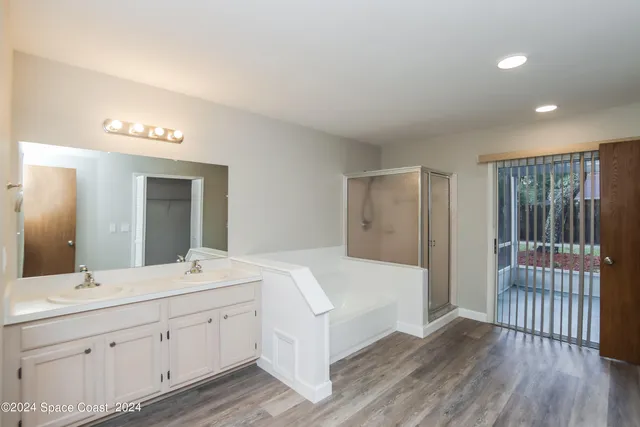 a en suite bathroom with a double vanity sink and a mirror