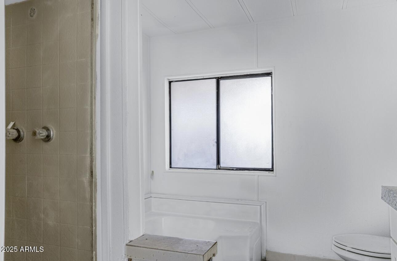 805 North Dysart Road, Unit 33 Avondale, AZ 85323 - Photo 17 of 18 a bathroom with a toilet sink and mirror