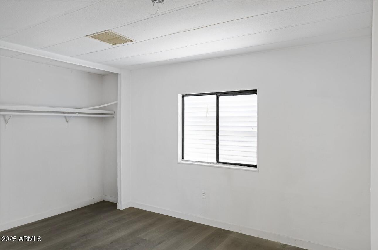 805 North Dysart Road, Unit 33 Avondale, AZ 85323 - Photo 8 of 18 a view of an empty room with wooden floor and a window