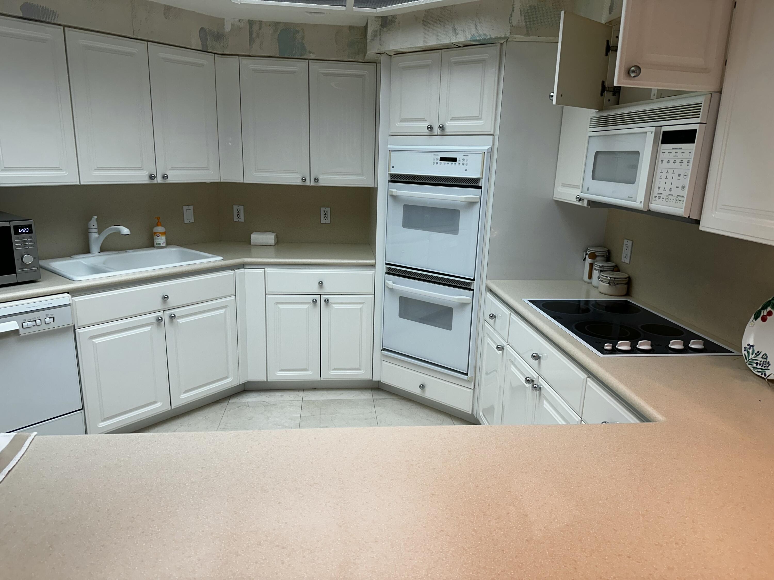 20320 Fairway Oaks Drive, Unit 373 Boca Raton, FL 33434 - Photo 24 of 27 a kitchen with cabinets appliances and a sink