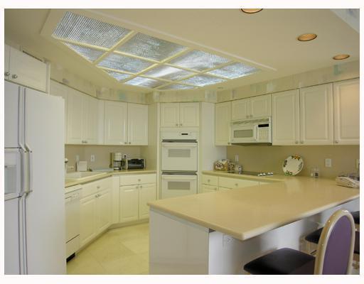 20320 Fairway Oaks Drive, Unit 373 Boca Raton, FL 33434 - Photo 25 of 27 a kitchen with a sink a stove cabinets and refrigerator