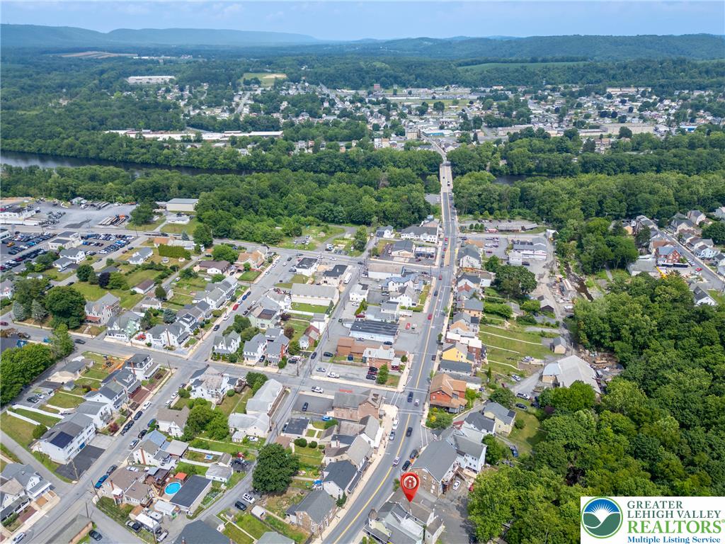313 Main Street Slatington, PA 18080 - Photo 69 of 73 An aerial perspective reveals a vibrant neighborhood nestled along a river, offering a blend of residential charm and natural beauty.