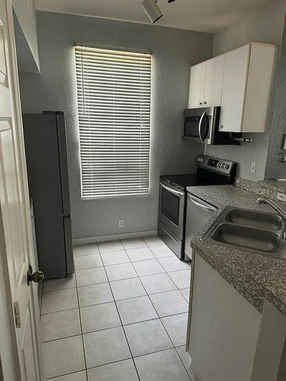 6392 Raleigh Street, Unit 2801 Orlando, FL 32835 - Photo 3 of 11 a kitchen with granite countertop a stove a sink a microwave and refrigerator