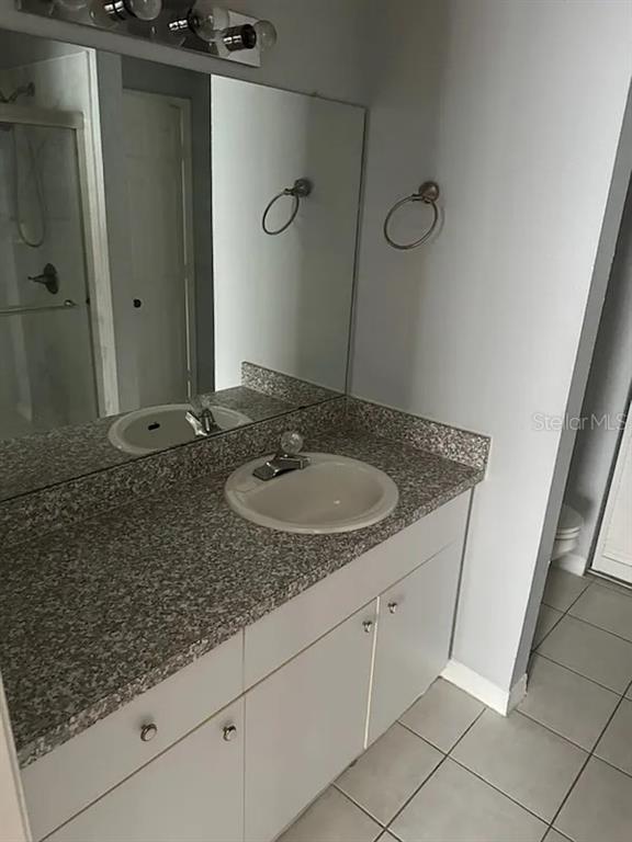 6392 Raleigh Street, Unit 2801 Orlando, FL 32835 - Photo 8 of 11 a bathroom with a granite countertop sink and a mirror