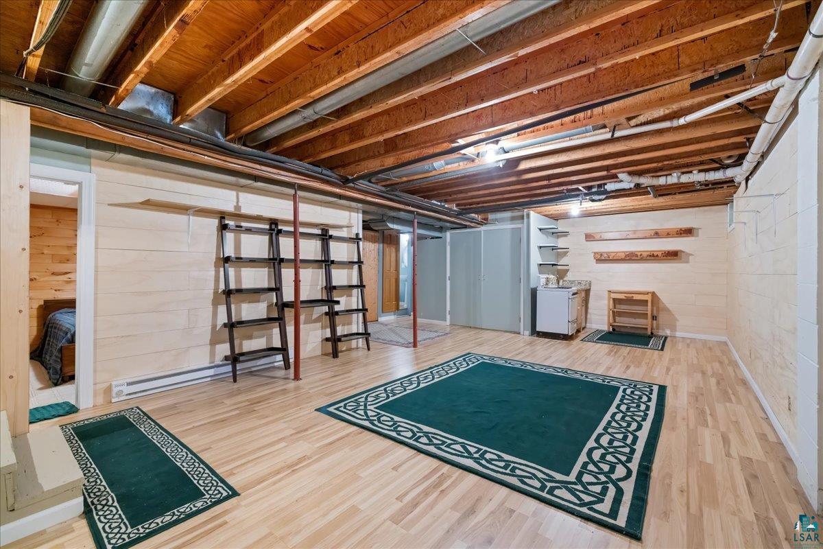1804 North Bay Road Ely, MN 55731 - Photo 23 of 37 Basement featuring a baseboard heating unit and light hardwood / wood-style floors
