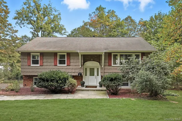 a front view of a house with a garden and plants