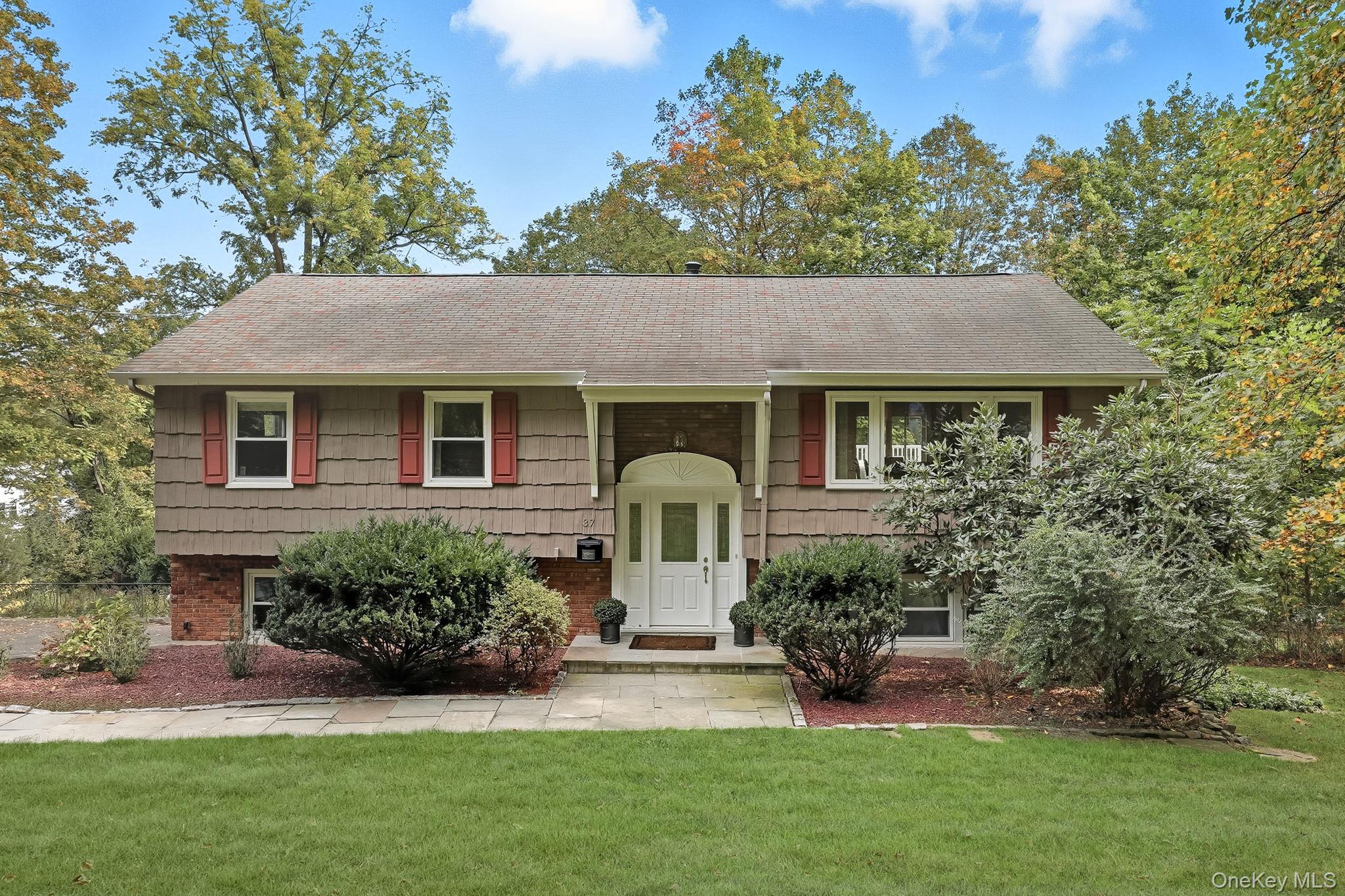 a front view of a house with a garden and plants