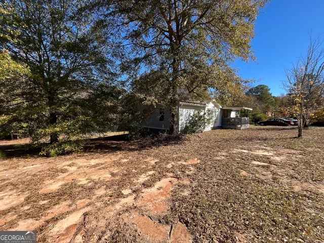 an aerial view of a house with a yard and mountain view in back