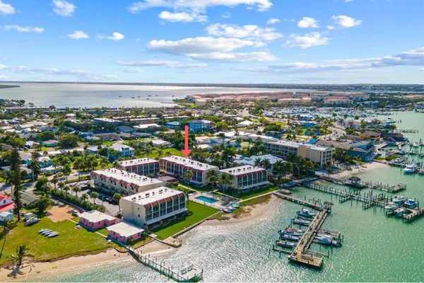 an aerial view of a city with lots of residential buildings ocean and mountain view in back